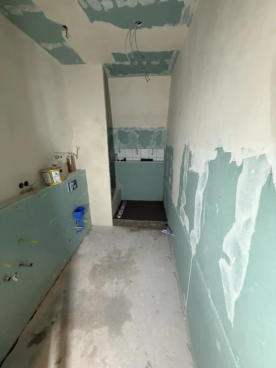 Badezimmer vor der Sanierung — Rohbau mit Trockenbau und offenen Leitungen
