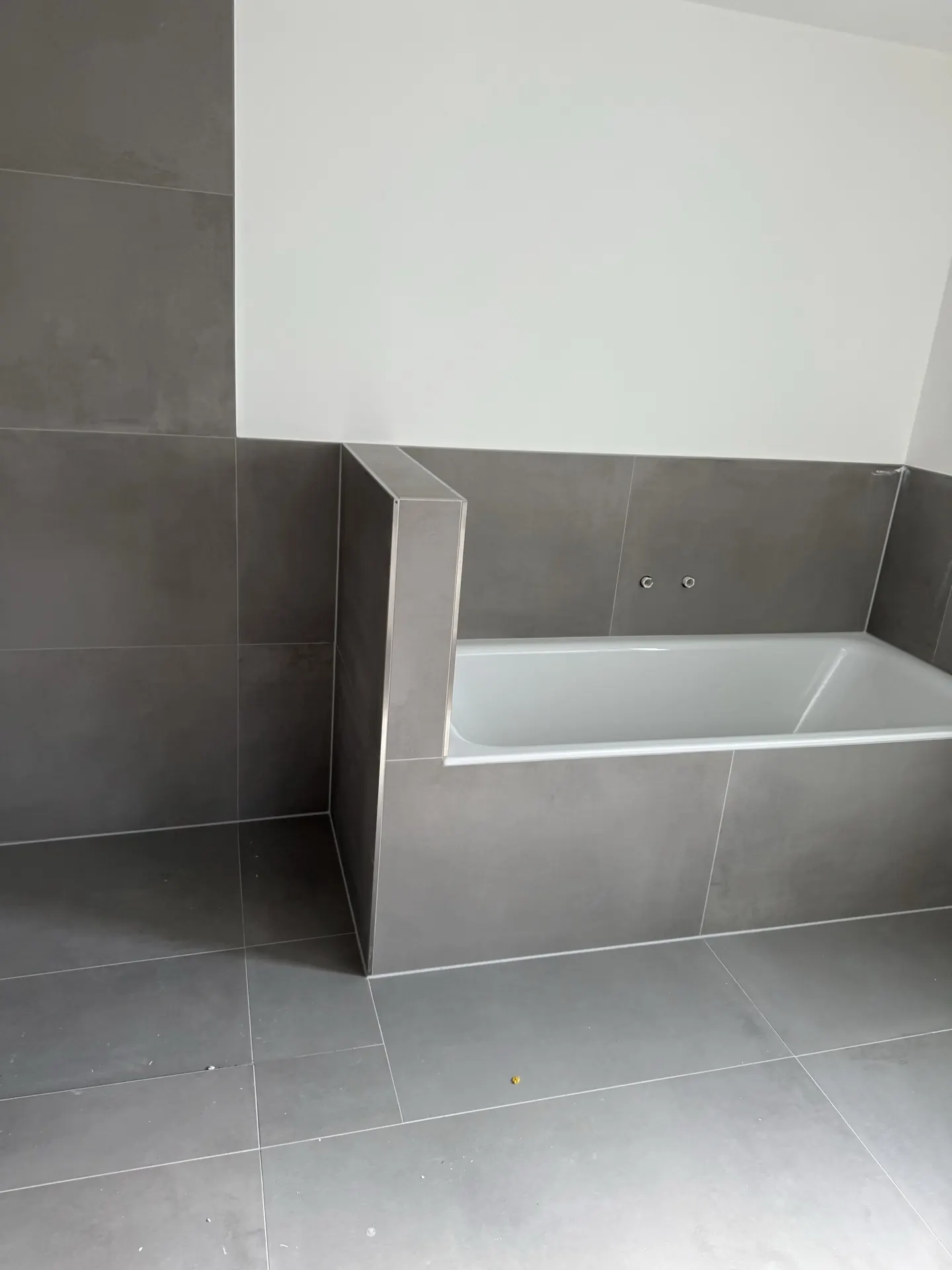 Badewanne mit dunkelgrauen Großformat-Fliesen — Badsanierung Mülheim an der Ruhr