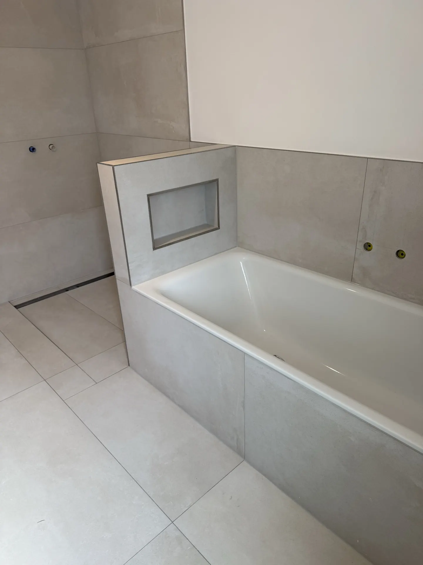 Badewanne und Duschbereich Gesamtansicht mit hellen Fliesen — Badsanierung Mülheim