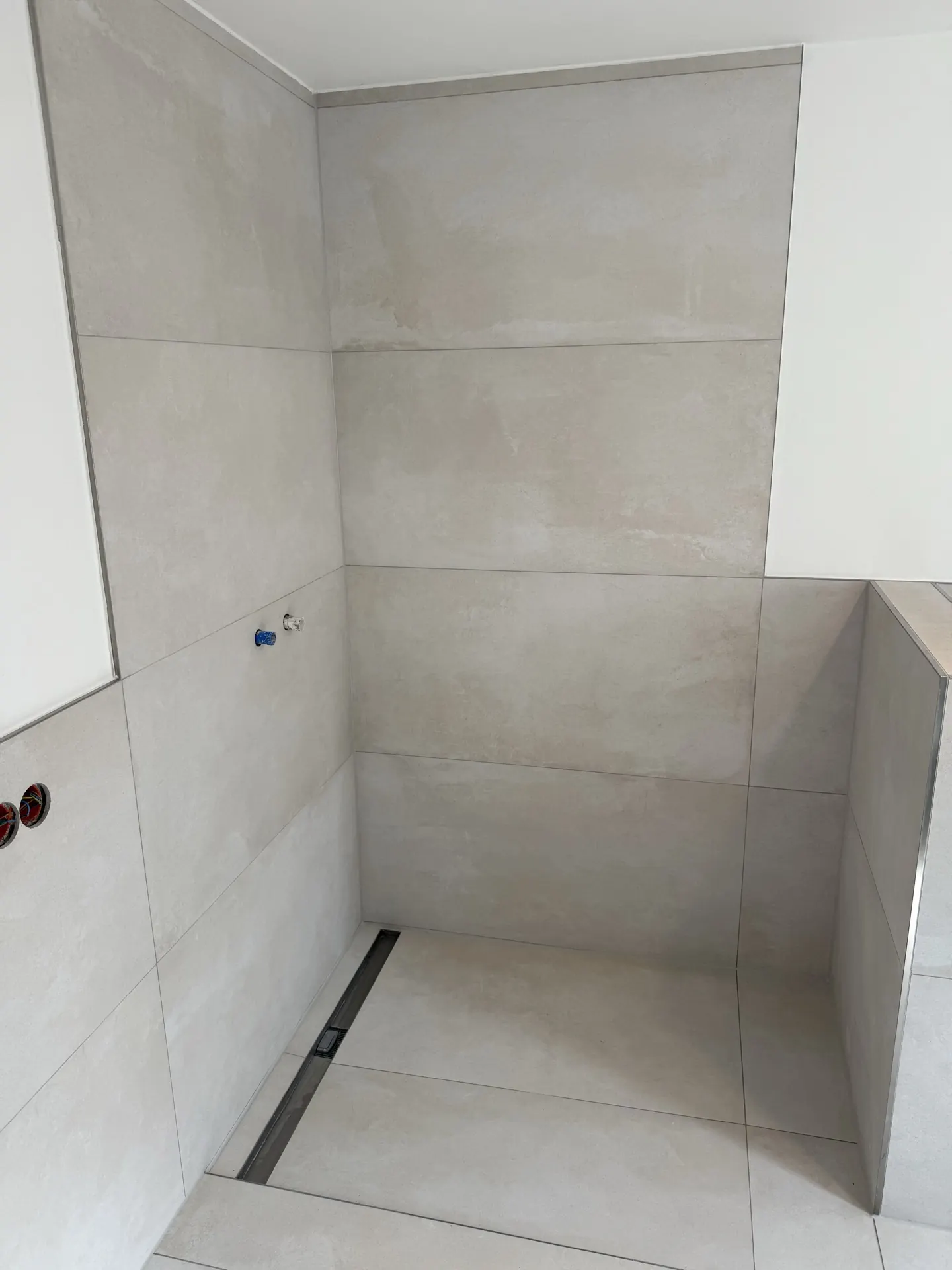 Duschbereich mit Großformat-Fliesen und Ablaufrinne — Badsanierung EVENT Bau