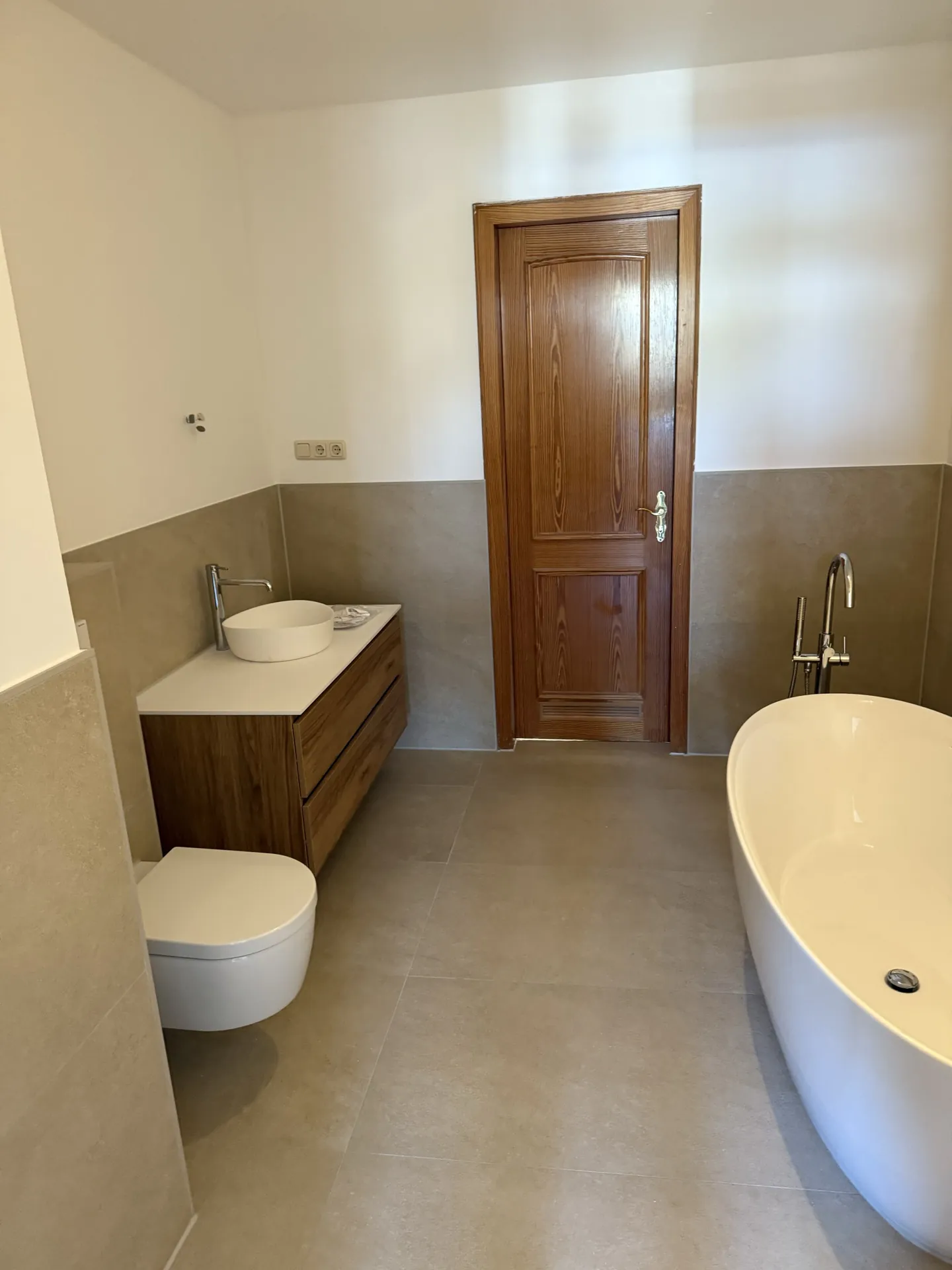 Holz-Waschtisch mit Aufsatzbecken und freistehende Badewanne — EVENT Bau